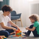 a man and a child playing with blocks on the floor